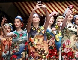 Models take selfie with mobile phones during the parade at the end of the Dolce & Gabbana Spring/Summer 2016 collection during Milan Fashion Week