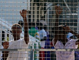 Immigrants stand in a refugee centre after Pope Francis' visit in Lampedusa