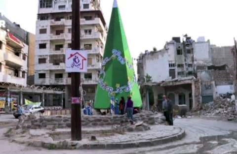Siria, a Homs la festa intorno all’albero fatto di macerie
