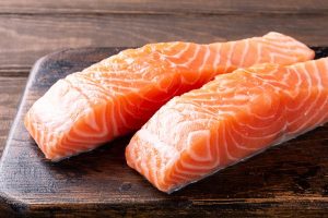 Fresh raw salmon fillet. Old wooden background. Banner selective focus.